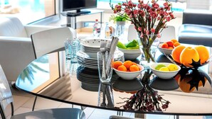 Una mesa de comedor con platos, tazones y un florero.