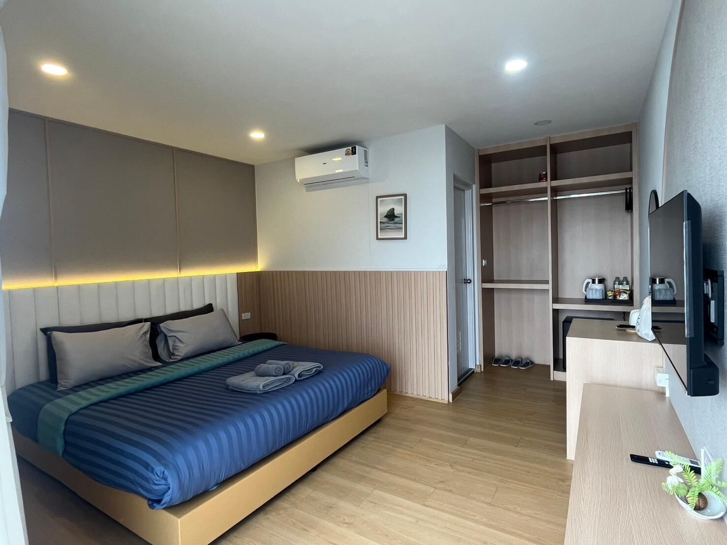 Una habitación de hotel moderna con cama, armario empotrado y televisor.