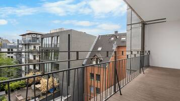 A balcony with a view of neighboring buildings and a clear sky.