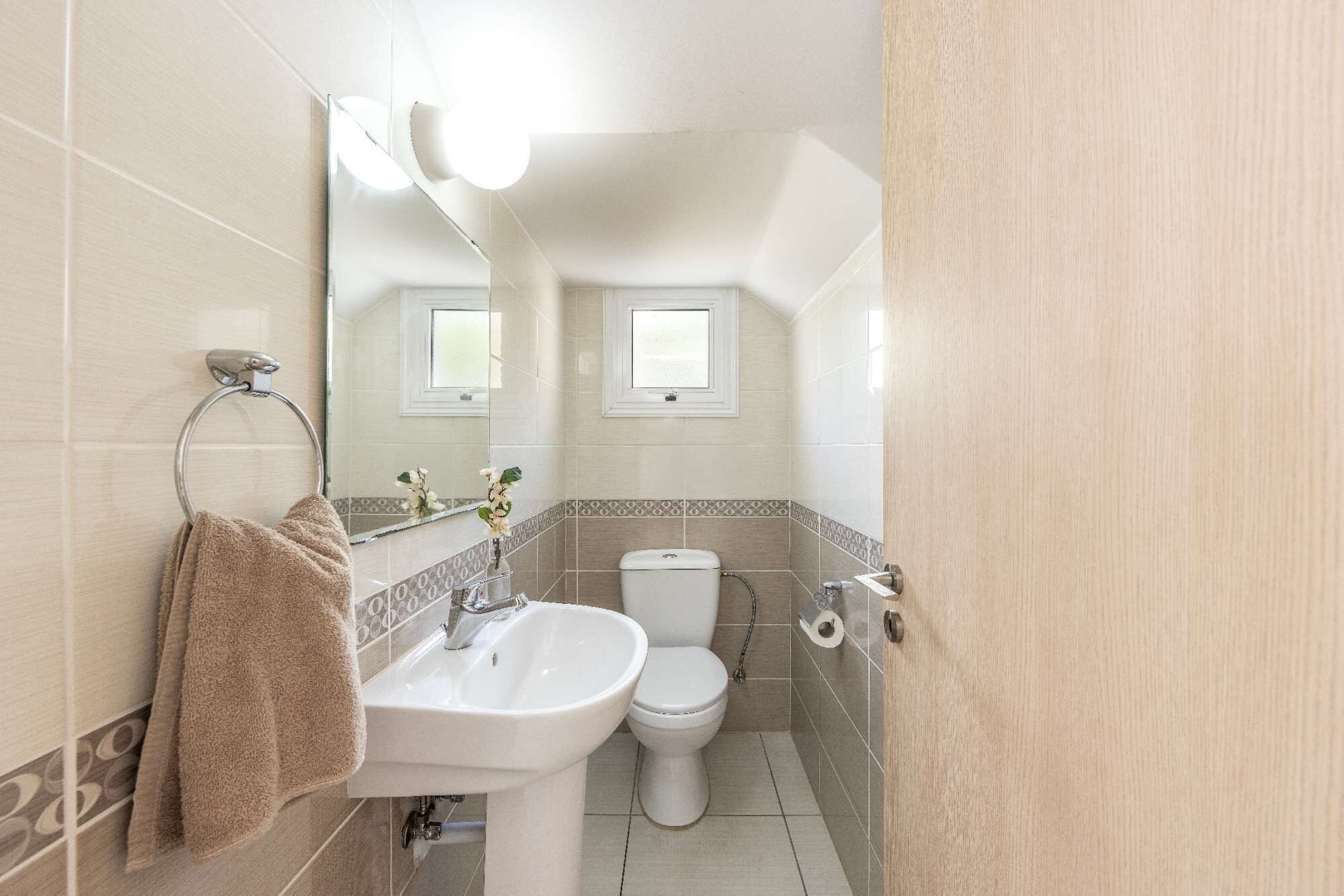 A bathroom with a sink, toilet, and a towel rack.