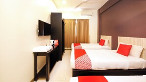 A hotel room with two beds, a flat-screen TV, a desk with a coffee maker, and a ceiling fan. - Hotel O Batu Ferringhi Beach formerly ESQ Ferringhi (George Town)