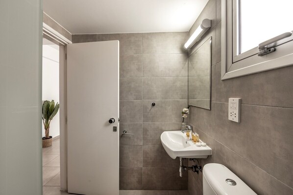 A modern bathroom with a shower, sink, and toilet. - Studio apartment in the heart of Protaras (Protaras)