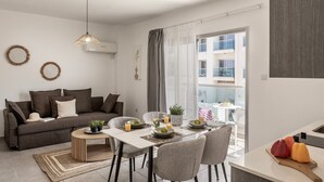 Un appartement moderne doté d’un coin repas, d’un canapé et d’un balcon avec vue.
