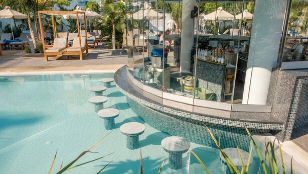 A pool with lounge chairs and a bar area. - 1 bedroom apartment in the heart of Protaras (Protaras)