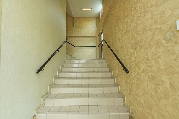 A staircase with white tiles and black handrails, leading to an upper floor. - Collection O Melaka Near Dataran Pahlawan Formerly Ideals Hotel (Malacca City)