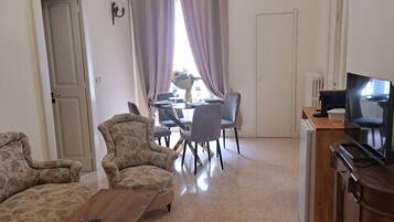 Suite familiare, vista città | Area soggiorno | Smart TV 32 pollici con canali satellitari, caminetto, Netflix