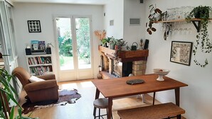 Un salon spacieux avec une table à manger en bois, un canapé confortable et une grande fenêtre donnant sur un paysage verdoyant.