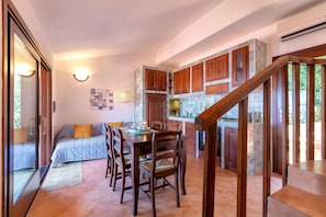 Une cuisine moderne avec des meubles en bois, un coin repas comprenant une table et des chaises, et un escalier menant à un niveau sup érieur.