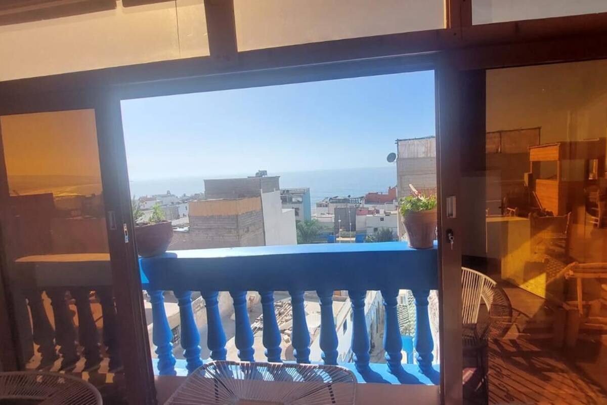 A balcony with a view of the sea and buildings.