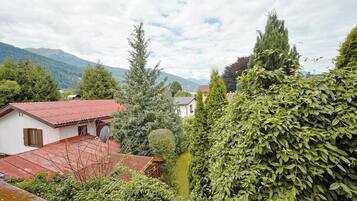 Un quartiere residenziale con case, un edificio con tetto rosso e montagne sullo sfondo.