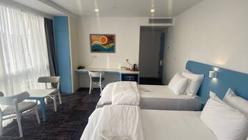 Habitación triple familiar, vista a la ciudad | Escritorio, espacio para trabajar con laptop y wifi gratis