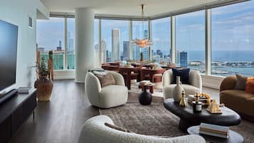 A spacious living room with a city view, modern furniture, and a large window.