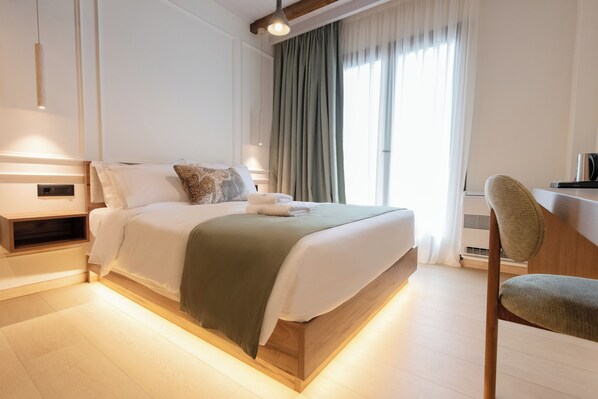 Un dormitorio moderno con una cama de madera, una mesita de noche, una silla y un ventanal con cortinas.