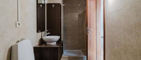 A bathroom with a toilet, sink, and shower.