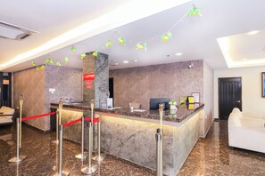 A hotel reception area with a marble counter, a red rope barrier, and a reception desk. - Collection O Bukit Bintang Formerly Midaris (Kuala Lumpur)