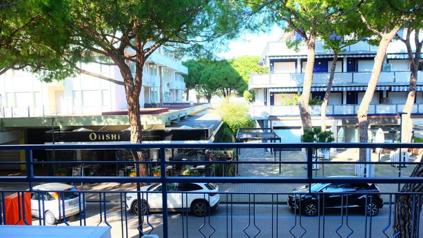 A street view with a building labeled 'Onishi' and a fence in the foreground. - Apartment 'Ellidor 01' with Private Terrace and Air Conditioning (Lido di Jesolo)