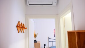 An air conditioning unit mounted on the ceiling, a wooden door frame, and a small white table with a lamp. - Apartment 'Ellidor 01' with Private Terrace and Air Conditioning (Lido di Jesolo)