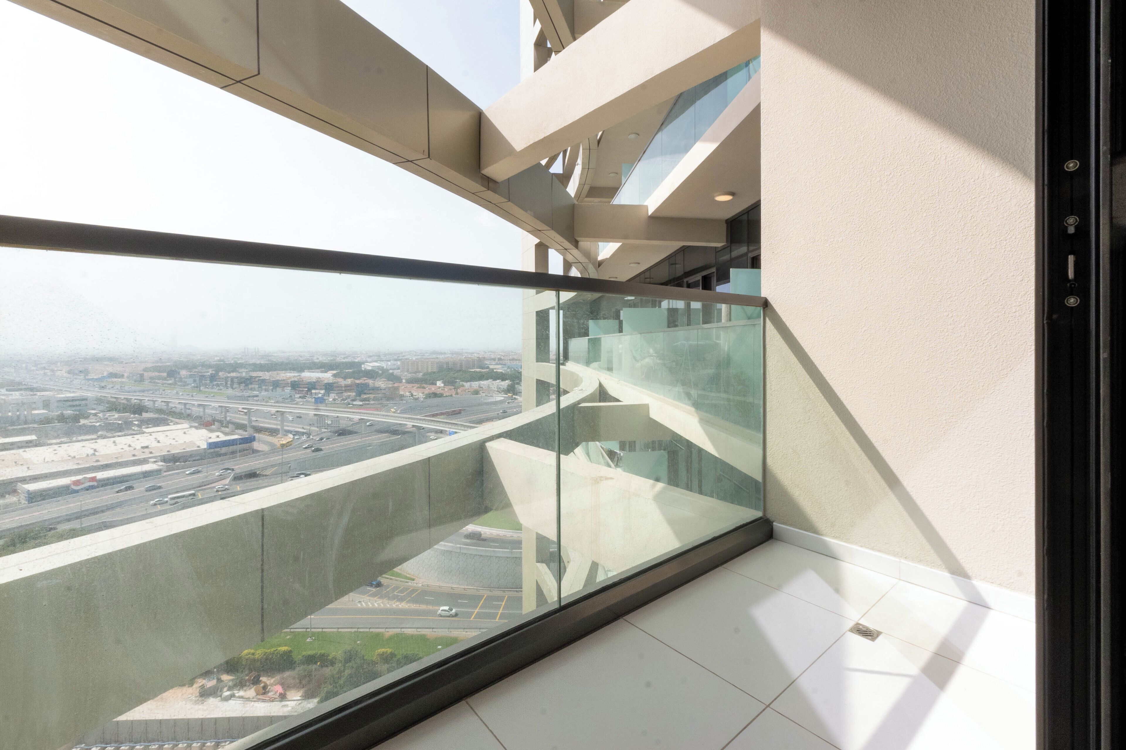 Een hoog gebouw met een glazen balkon met uitzicht op een stadsgezicht.