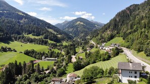 Ein ländliches Dorf mit Häusern, einer Straße und umliegenden Bergen.