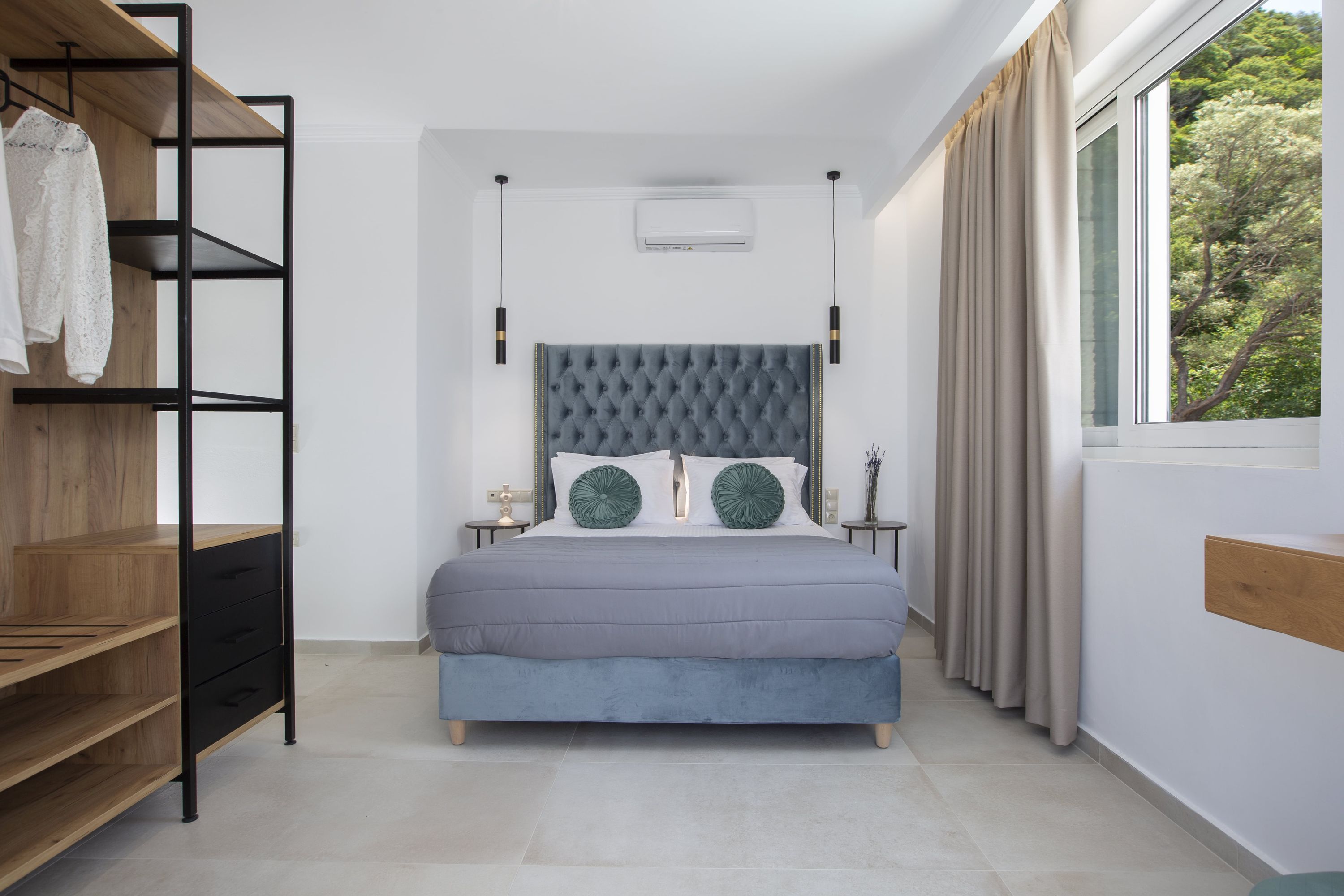 A bedroom with a bed, a wardrobe, a nightstand, and a window with curtains.