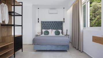 A bedroom with a bed, a wardrobe, a nightstand, and a window with curtains.
