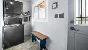 A compact kitchen with a built-in oven, a window, and a door with a handle. - All season Lakefront cottage! (MacTier)