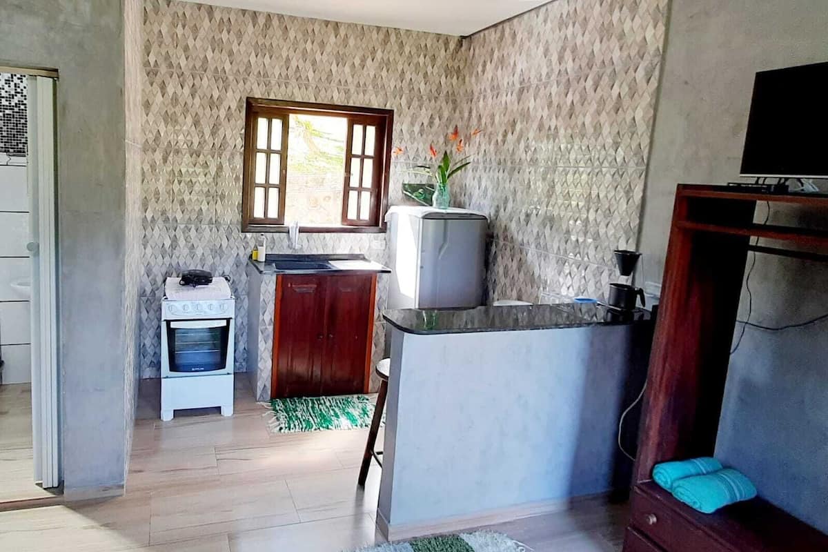 A compact kitchen with a stove, sink, and a small refrigerator.