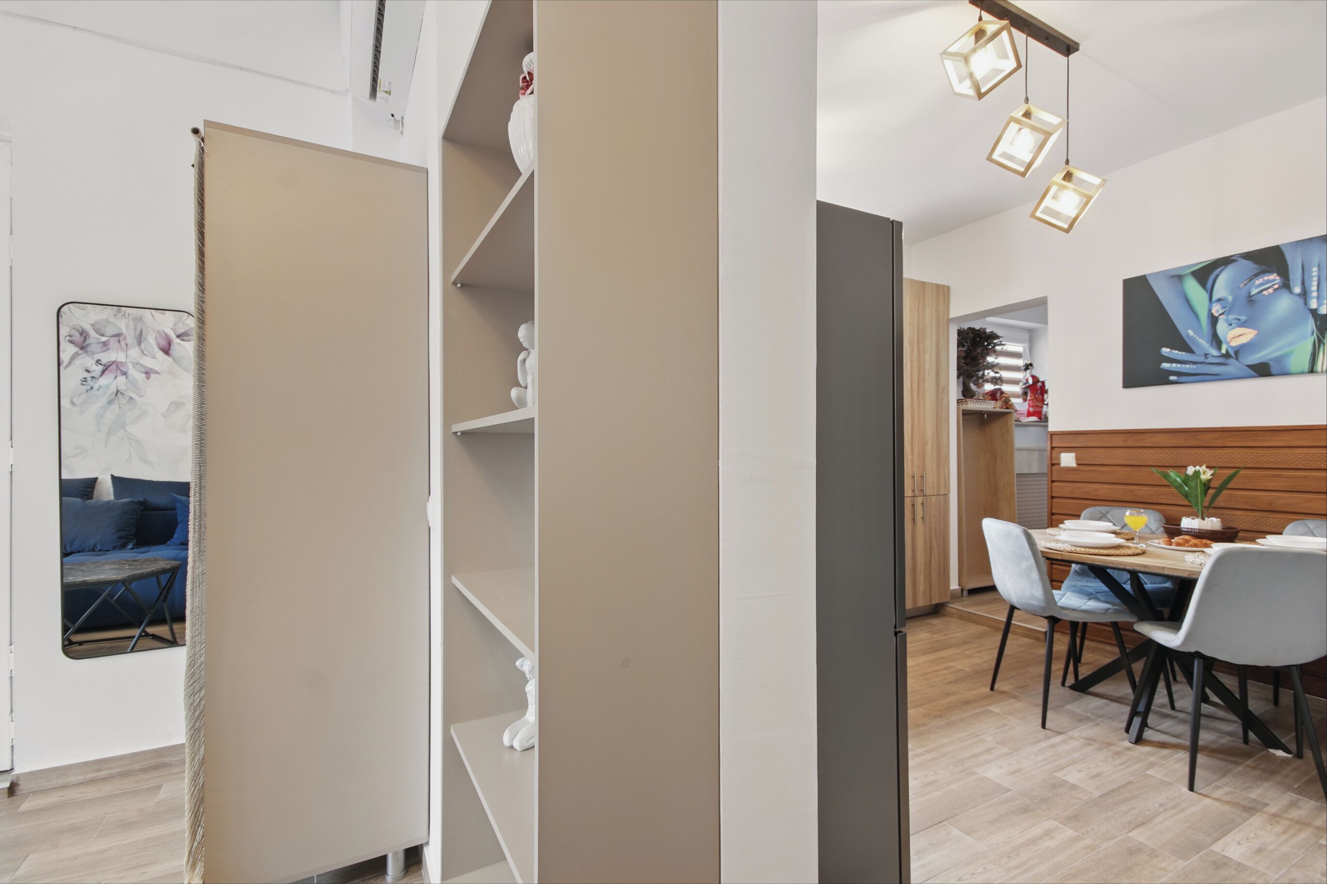 Un comedor moderno con una mesa de madera, sillas y una lámpara colgante.