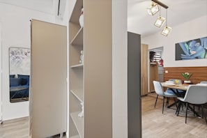 A modern dining area with a wooden table, chairs, and a hanging light fixture. - Petru Maior Apartments (Bucharest)
