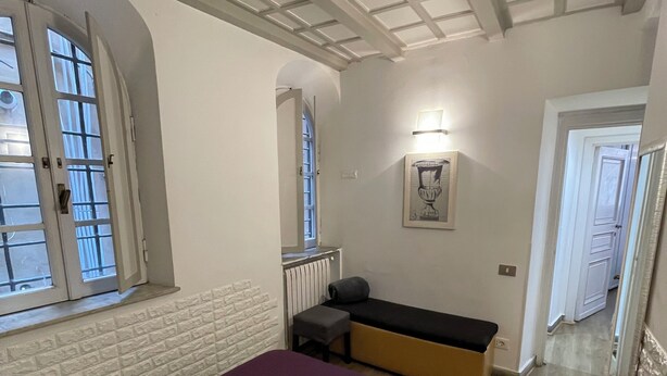A bedroom with a bed, a bench, a window, and a door. - Quite and relax in the real center of Rome (Unknown)