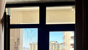 Una habitación con un ventanal que da a una vista urbana.