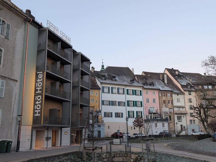 A hotel with a modern facade, multiple balconies, and a sign indicating it is a hotel.