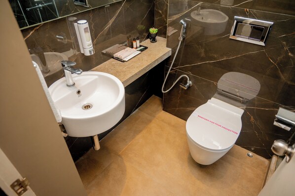 A modern bathroom with a white sink, a toilet, and a shower. - Urvi Banquets & Guest House  (Bidhannagar)