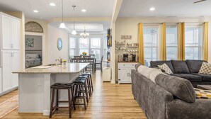 A spacious kitchen with a central island, bar stools, and a dining area. - Wild Air Getaway For 12! (Frankford)