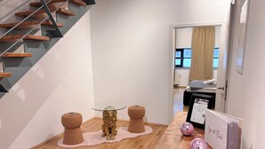 A modern interior with a staircase, a glass-top table with a lion statue, and a 'Guest Book' sign. - Perfect for families, right in the center incl. elevator (Dortmund)
