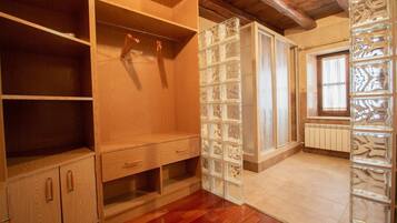 A room with wooden cabinets, a glass block partition, and a window with blinds.