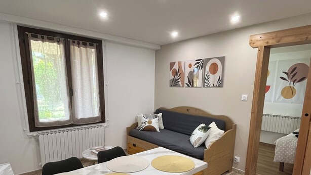 A compact living space with a dining area, a sofa, and a small kitchenette. - T2 apartment for rent (Chorges)