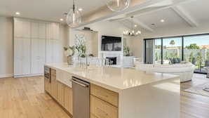 A modern kitchen with a large island, wooden cabinets, and a dishwasher. - Upscale Oasis! Luxe Chandler Gem w/ Patio (Chandler)