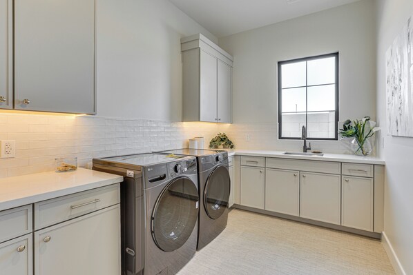 A modern kitchen with stainless steel appliances, white cabinetry, and a large window providing natural light. - Upscale Oasis! Luxe Chandler Gem w/ Patio (Chandler)