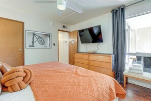 A bedroom with a bed, a wooden dresser, a television mounted on the wall, and a window with curtains. - < 1 Mi to Old Town: Scottsdale Condo w/ Balcony (Scottsdale)