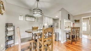 A kitchen with wooden cabinets, a stainless steel refrigerator, and a hanging light fixture. - 1 Block to Hiking: Ruidoso Home w/ Game Room (Ruidoso)