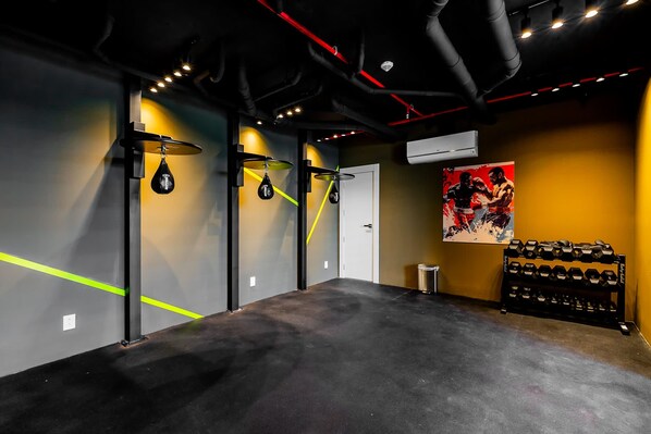 A gym with weightlifting equipment, a punching bag, and a motivational poster on the wall. - w Elegant 2BR Apartment in the Heart of Centriqo (Veracruz)