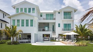 A multi-story white building with balconies, a swimming pool, and outdoor seating. - New Waterfront Home - Dreamside House (Key West)