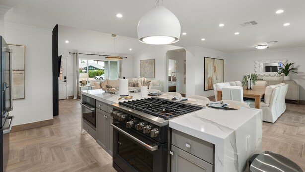 A modern kitchen with a central island, built-in oven, and stainless steel appliances. - NEW The Hensley on Hubbell Designer Oasis w Pool (Scottsdale)