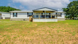 A single-story mobile home with a covered porch and a small staircase leading to the entrance.