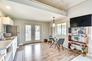 Una cocina moderna con comedor, pisos de madera y un ventanal grande.