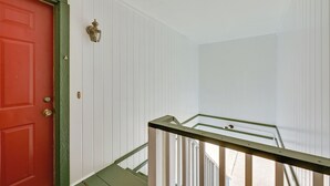 A staircase with a red door and white walls. - Nacogdoches Condo Half-mi to Sfa: Pets Welcome (Nacogdoches)