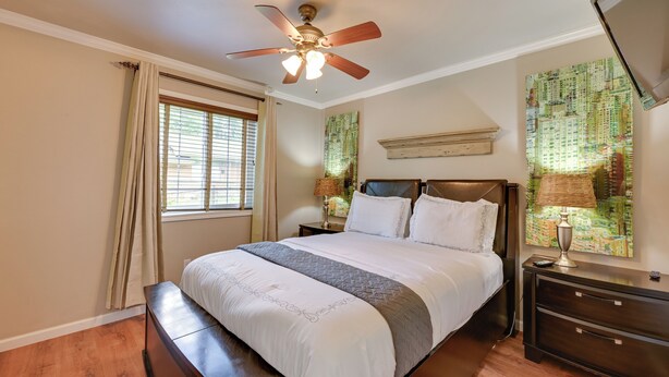 A bedroom with a bed, a ceiling fan, a nightstand, a lamp, and a window with curtains. - Walk to SFA Campus: Pet-friendly Nacogdoches Condo (Nacogdoches)
