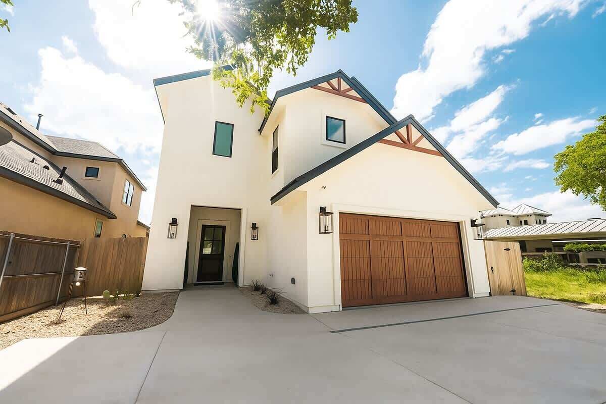 A modern two-story house with a garage, a front door, and a driveway.