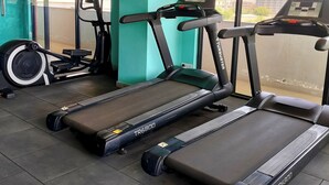 Academia com esteiras, bicicleta ergométrica e remo.